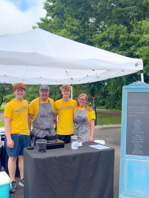 Nate, Carla, and their two sons together at the Nate's Crepes market stand